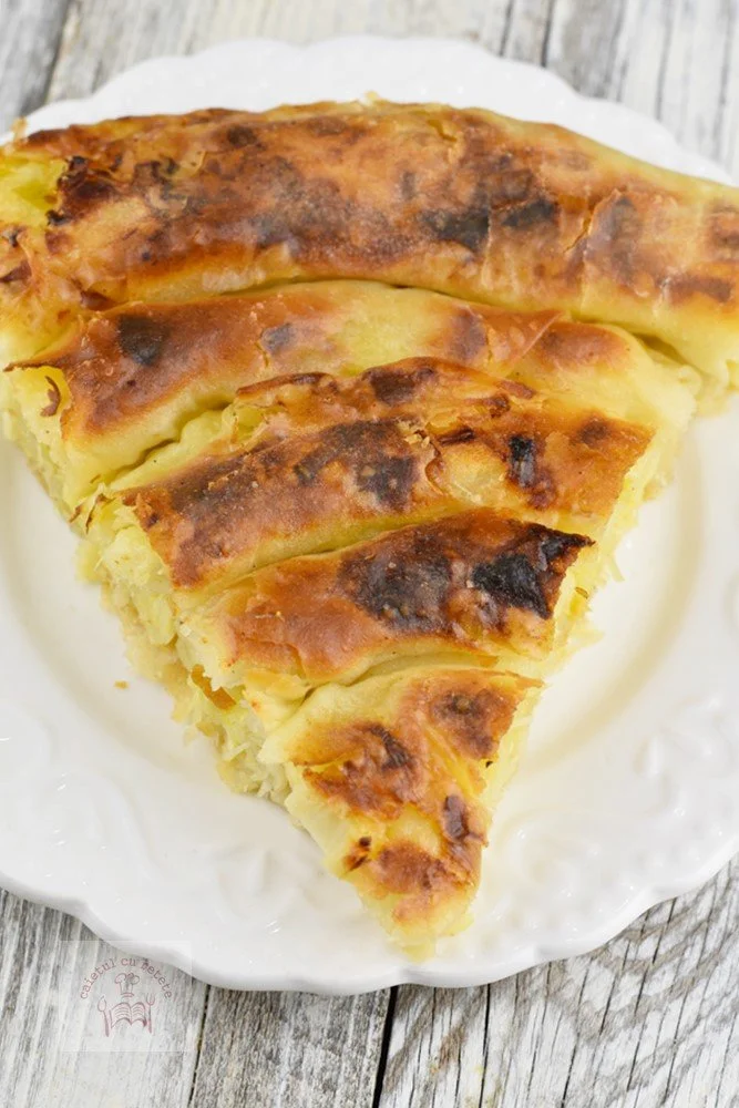 Plăcintă cu brânză și praz proaspăt, servită pe farfurie