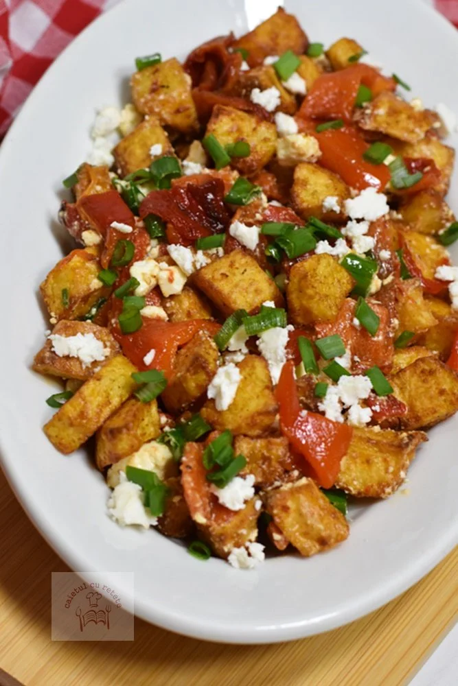 Salată de cartofi cu ardei copți și brânză feta, servită într-un bol.