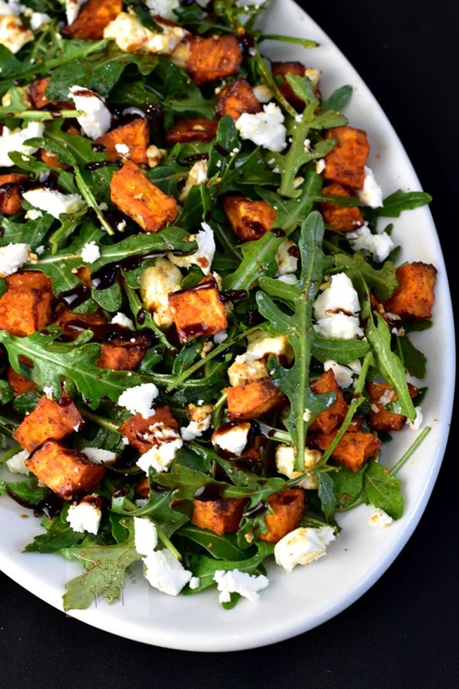 Salată de rucola cu cartofi dulci și brânză feta, gata de servit.