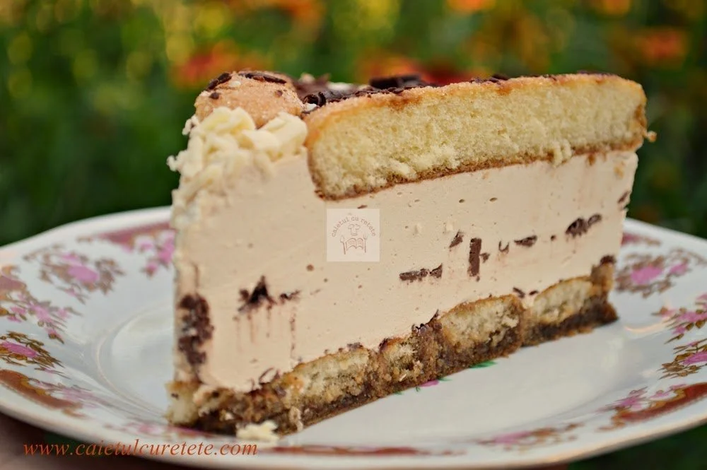 Tort cu pișcoturi și nes decorat cu ciocolată și fructe.